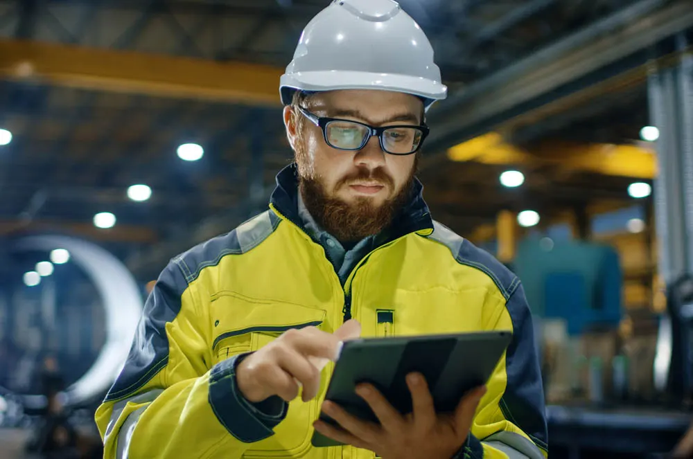 Technicien avec une tablette dans un atelier de métallurgie