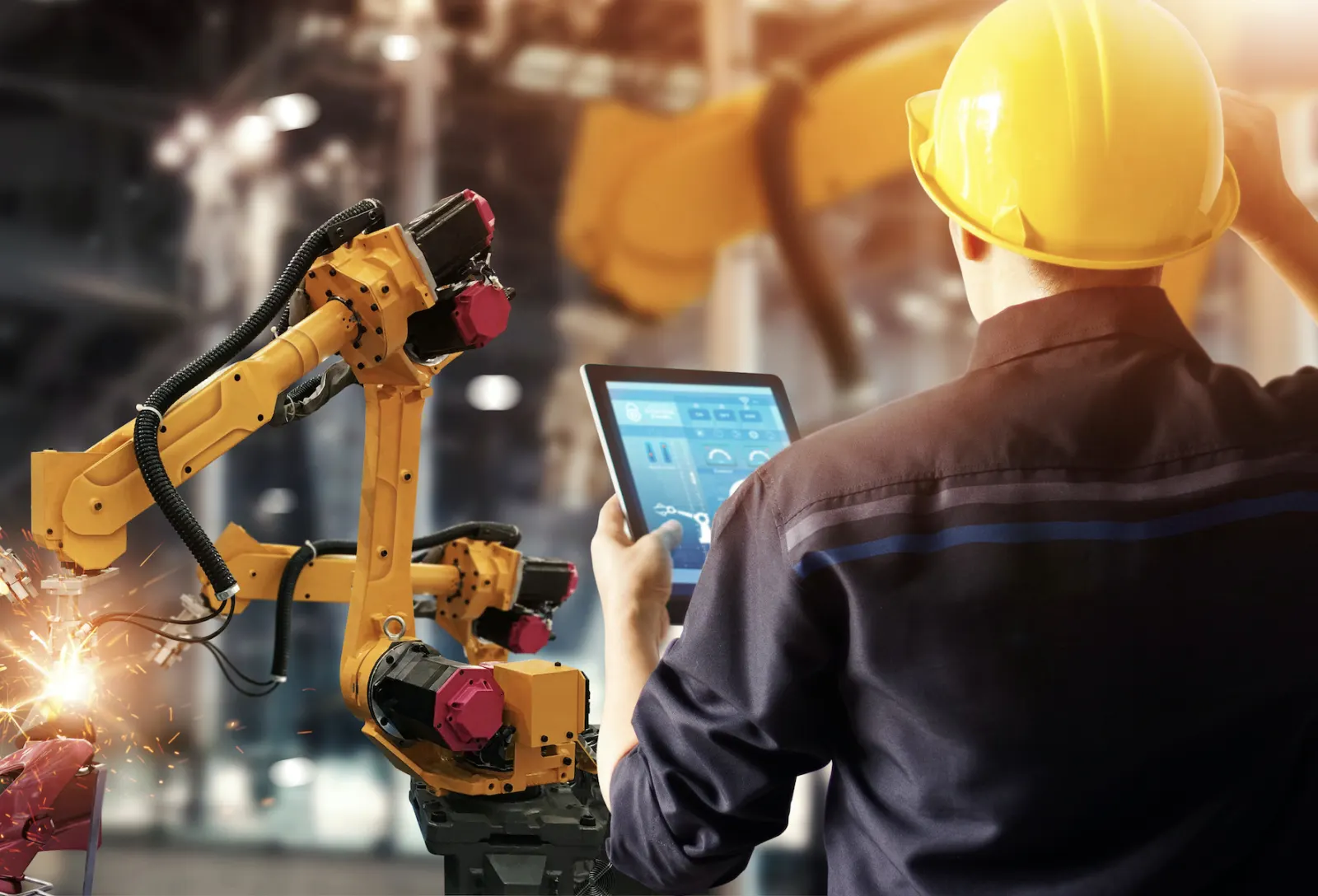 Opérateur pilotant un robot de soudage depuis une tablette