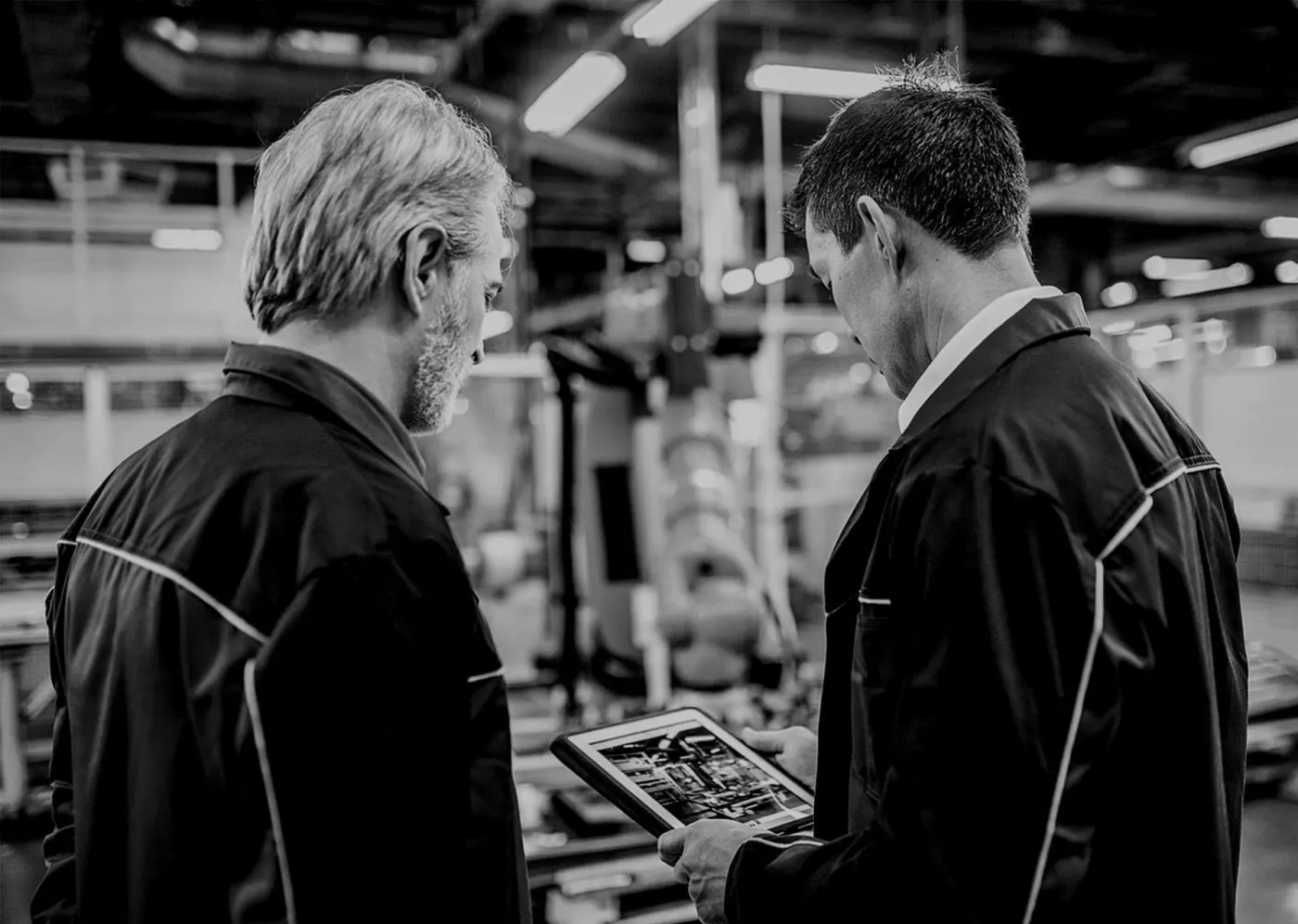 Deux techniciens consultent une tablette dans un atelier