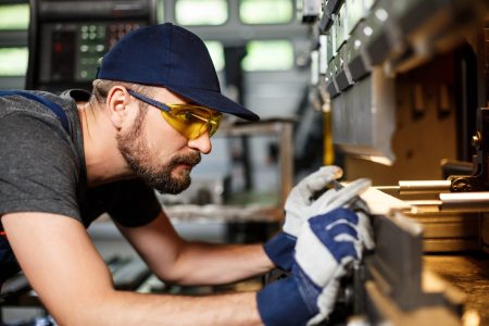 “Portrait-of-worker-near-metalworking-machine-steel-factory-background”
